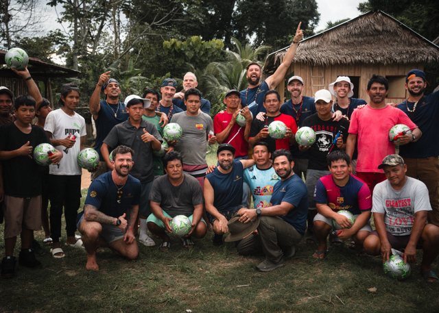 The 88 Souls 4 Soccer outreach team with villagers, everyone holding new soccer balls